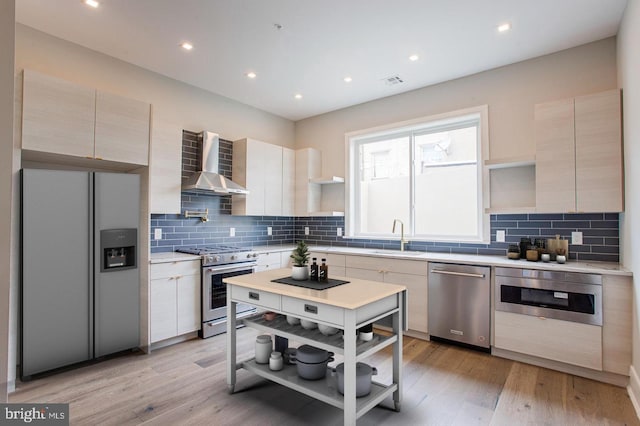 kitchen with open shelves, wall chimney range hood, appliances with stainless steel finishes, and light countertops