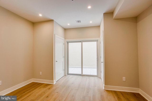 unfurnished room featuring recessed lighting, visible vents, light wood-style flooring, and baseboards