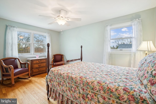 bedroom with light wood finished floors, multiple windows, and a ceiling fan