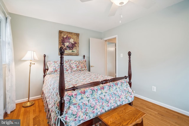 bedroom with a ceiling fan, baseboards, and wood finished floors