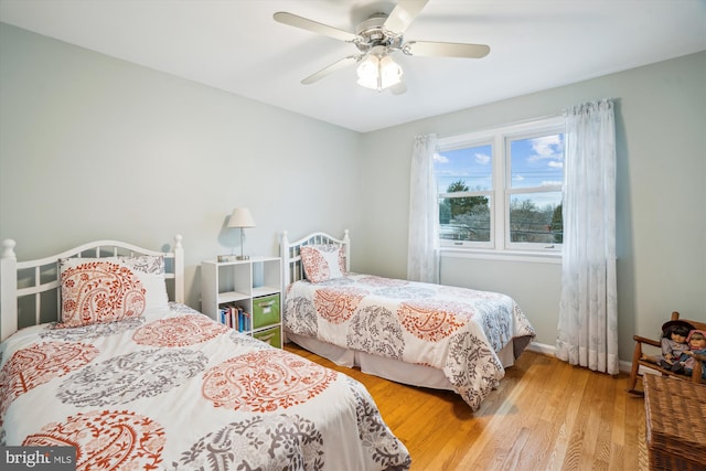 bedroom with a ceiling fan, baseboards, and wood finished floors