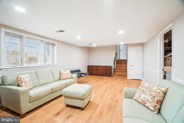 living area featuring light wood-style floors, recessed lighting, visible vents, and stairs