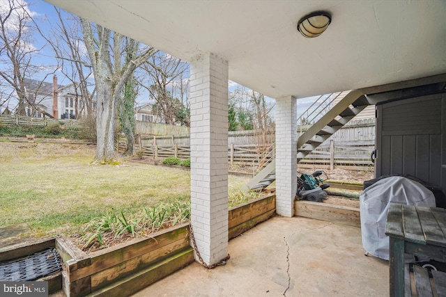 view of patio featuring a grill and fence