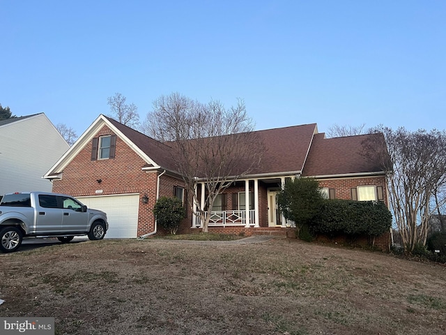 view of front of house featuring a garage, a porch, a front lawn, and brick siding