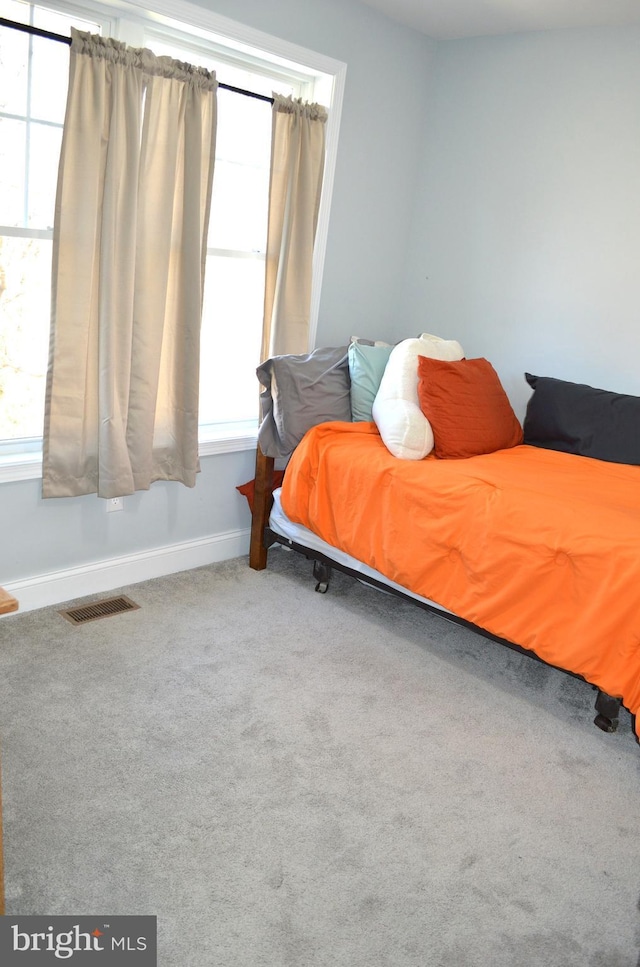 bedroom featuring carpet flooring, visible vents, and baseboards