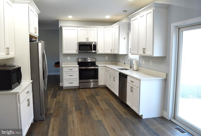 kitchen with white cabinets, appliances with stainless steel finishes, light countertops, and a sink