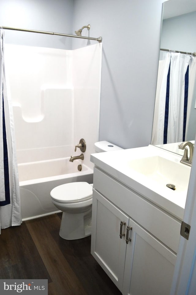 bathroom featuring toilet, shower / tub combo, wood finished floors, and vanity