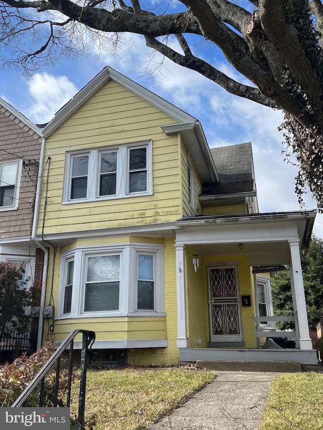 view of front facade with covered porch and brick siding