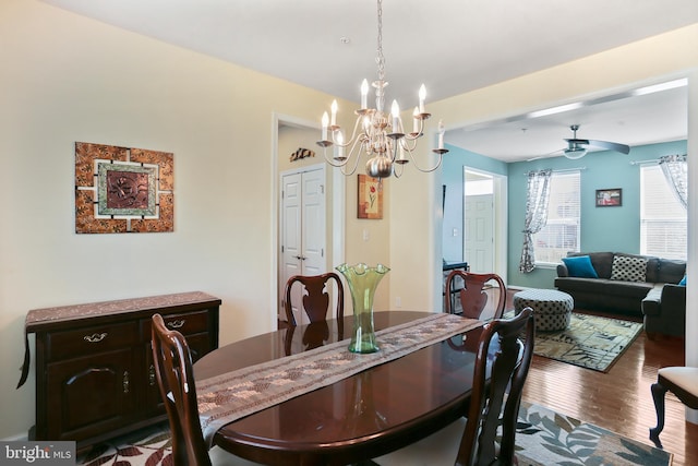 dining room featuring ceiling fan with notable chandelier and wood finished floors