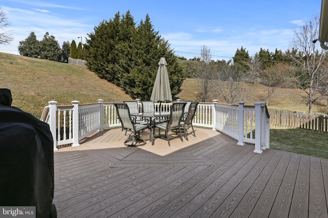 wooden deck with a grill, fence, a lawn, and outdoor dining space