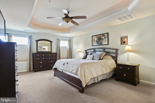 bedroom with multiple windows, carpet, a raised ceiling, and visible vents