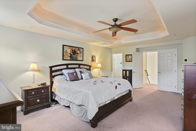 carpeted bedroom featuring a raised ceiling and ceiling fan