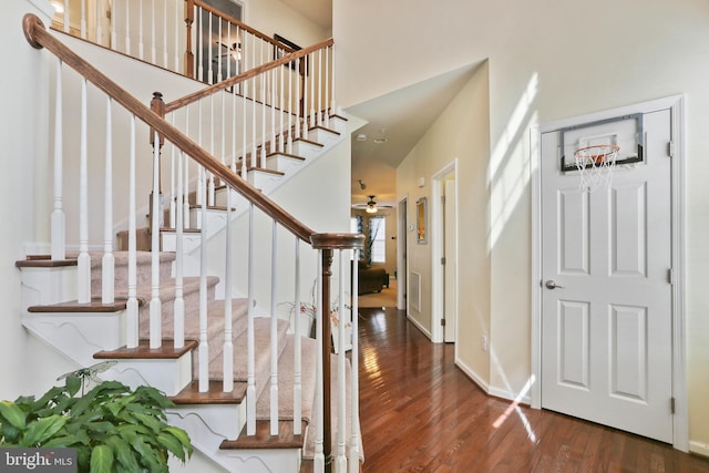 foyer entrance with visible vents, a high ceiling, ceiling fan, wood finished floors, and baseboards