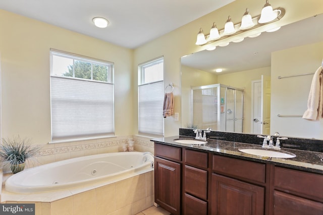 bathroom featuring a stall shower, a sink, a whirlpool tub, and double vanity