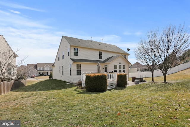 back of house featuring a yard, fence, and a deck