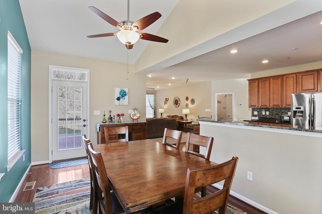 dining space with vaulted ceiling, plenty of natural light, dark wood finished floors, and recessed lighting