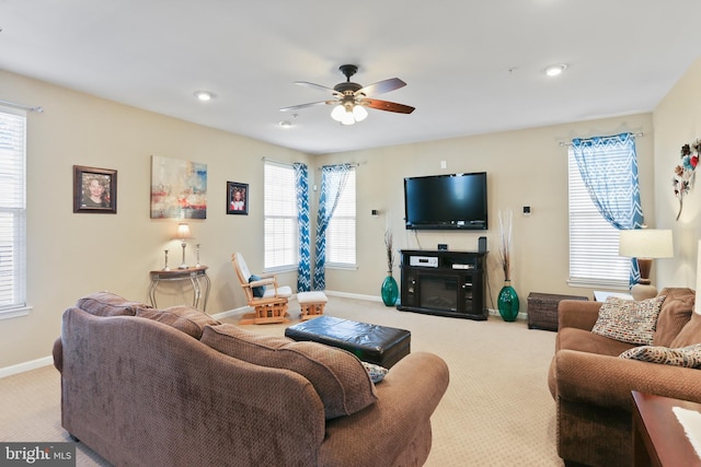 carpeted living room with baseboards, a ceiling fan, and a healthy amount of sunlight