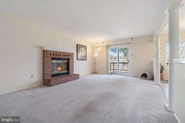 unfurnished living room with light carpet, a fireplace, and ornate columns