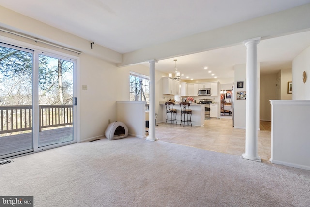 living area featuring recessed lighting, light colored carpet, baseboards, and ornate columns