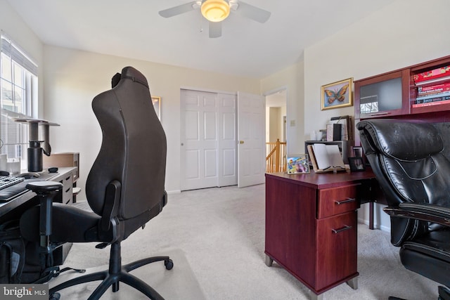 office area featuring a ceiling fan, light colored carpet, and baseboards