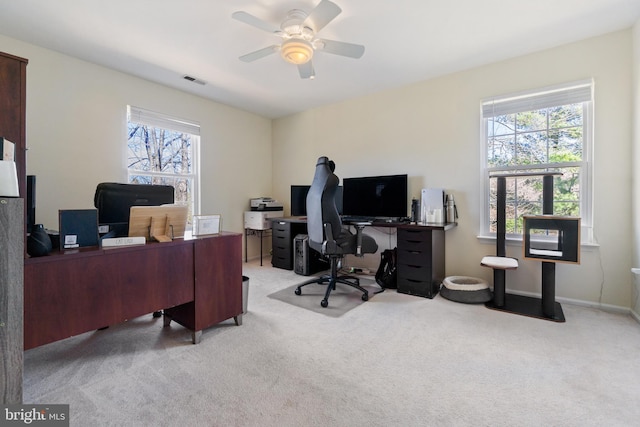 office with visible vents, light carpet, baseboards, and ceiling fan