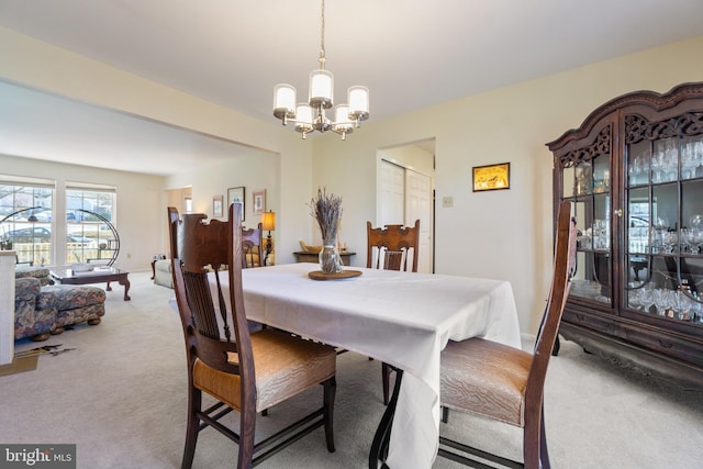 dining space with a notable chandelier and carpet flooring