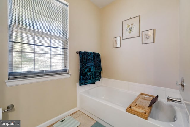 bathroom featuring a garden tub, baseboards, and tile patterned floors