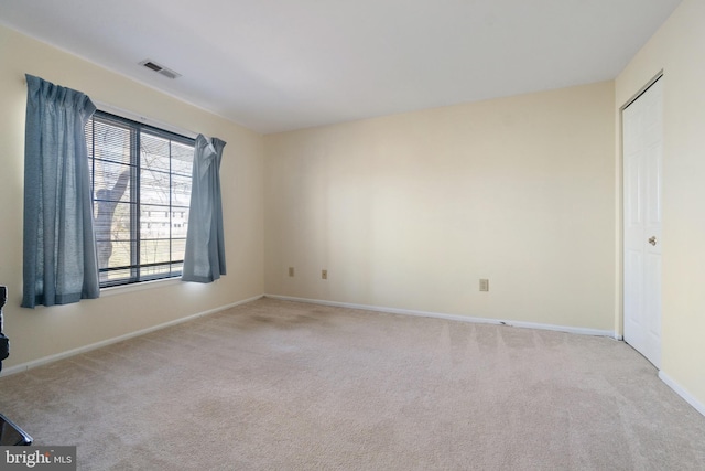 empty room featuring visible vents, baseboards, and carpet