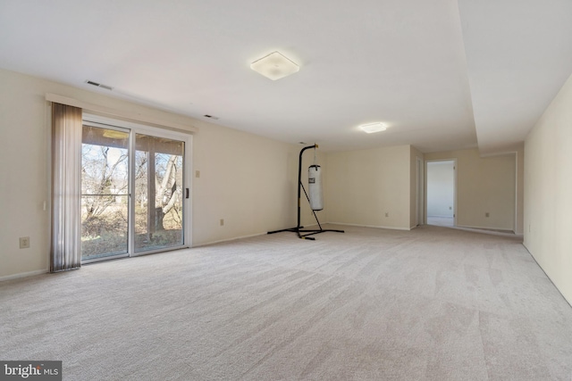 empty room featuring light carpet, visible vents, and baseboards