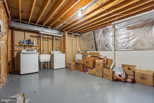 unfinished below grade area with a sink, separate washer and dryer, and concrete block wall