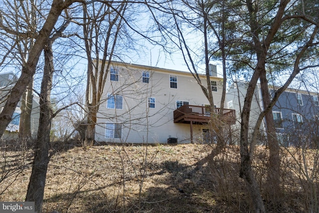 rear view of property featuring a deck and a chimney