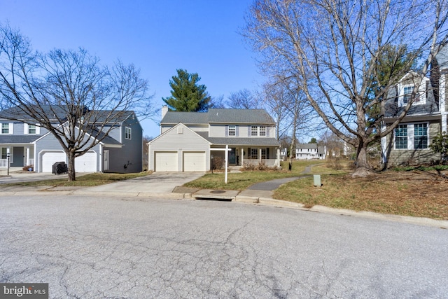 view of front of house with a chimney, an attached garage, a porch, and driveway