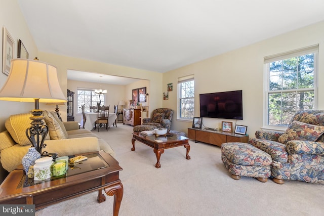 carpeted living room with a chandelier