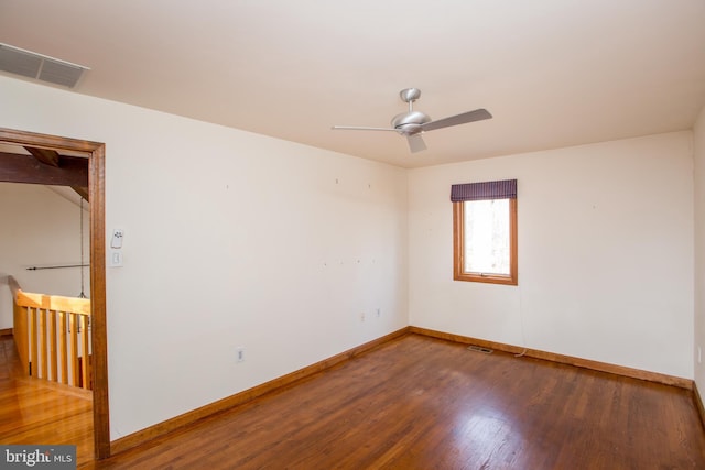 spare room featuring visible vents, baseboards, ceiling fan, and wood finished floors