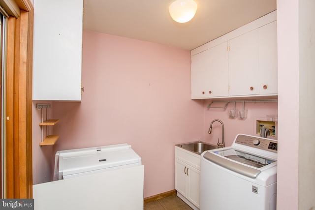 laundry room featuring washer and dryer, cabinet space, baseboards, and a sink