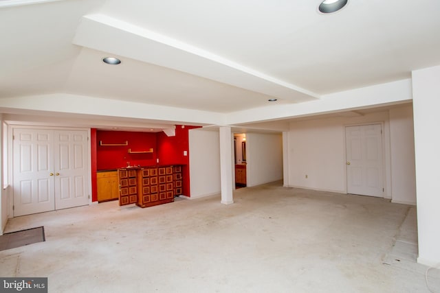 finished basement with indoor wet bar and recessed lighting