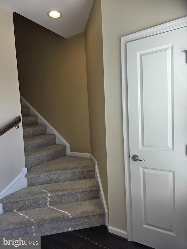 staircase featuring baseboards and recessed lighting