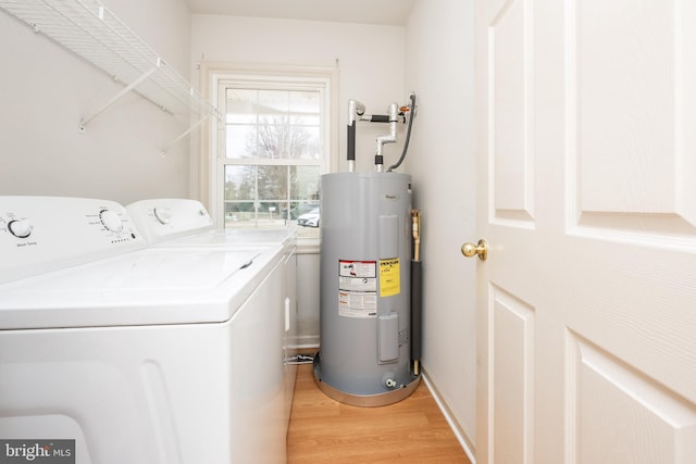 laundry room featuring light wood-style floors, washing machine and dryer, laundry area, and electric water heater