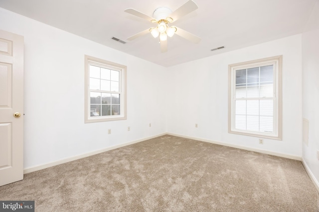 unfurnished room featuring ceiling fan, carpet, visible vents, and baseboards