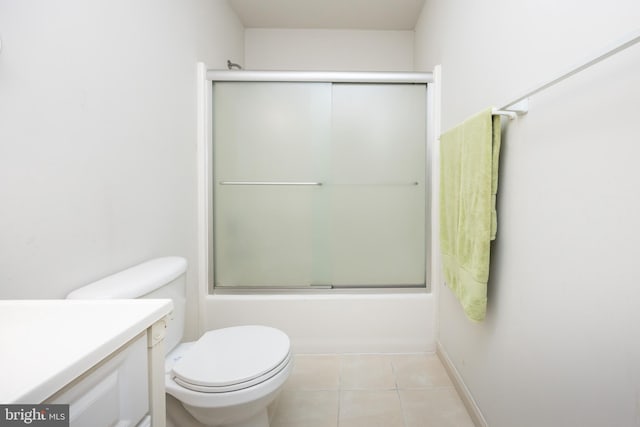 full bath featuring vanity, shower / bath combination with glass door, tile patterned flooring, and toilet