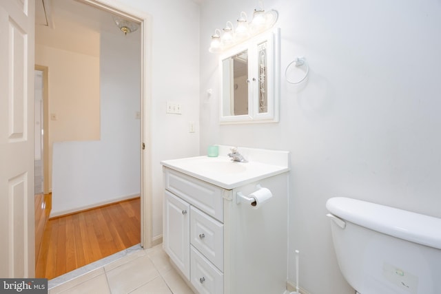 bathroom with toilet, tile patterned flooring, and vanity