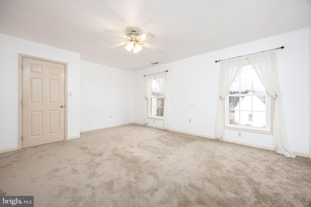 unfurnished room featuring carpet, visible vents, and baseboards