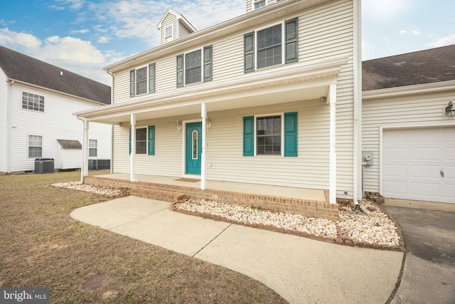 traditional style home featuring a garage, driveway, covered porch, cooling unit, and a front yard