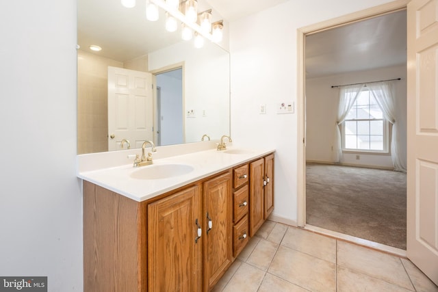 full bath with double vanity, a sink, baseboards, and tile patterned floors