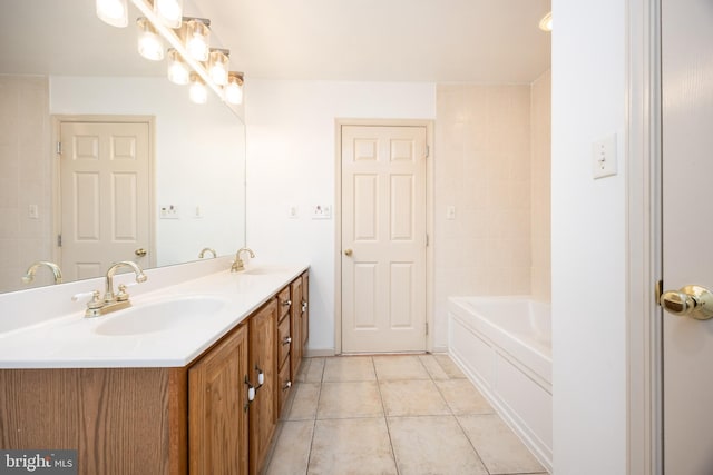 full bathroom featuring double vanity, a tub to relax in, a sink, and tile patterned floors