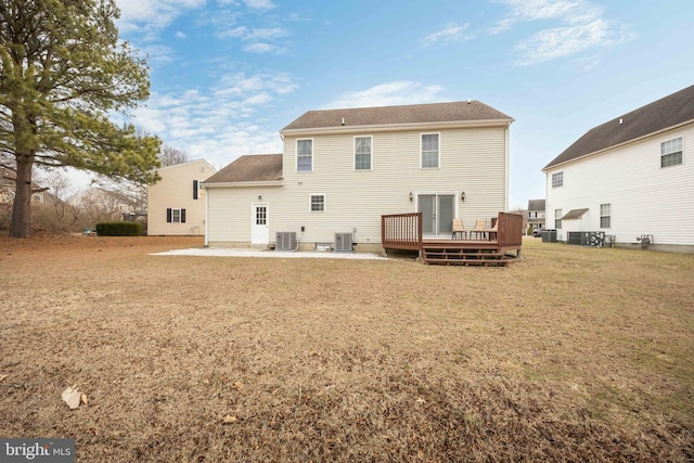 rear view of house with a wooden deck, a lawn, central AC, and a patio