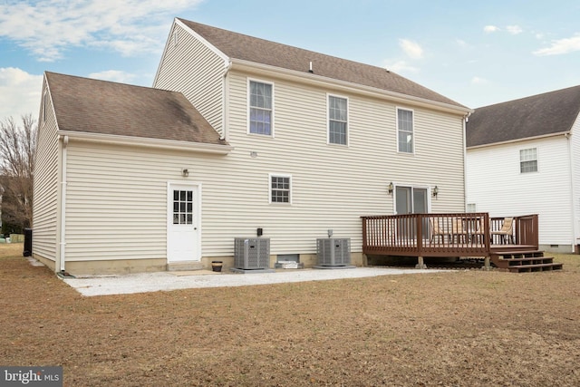 back of property featuring a shingled roof, a yard, a wooden deck, and central air condition unit