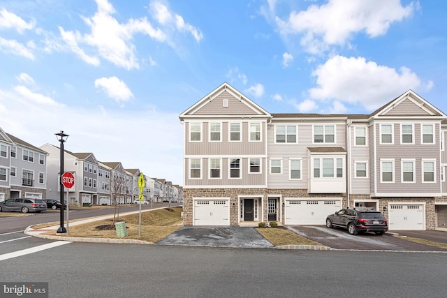 view of property featuring a residential view, driveway, and an attached garage