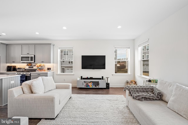 living area featuring dark wood-type flooring, recessed lighting, and baseboards