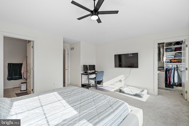 bedroom with carpet flooring, visible vents, baseboards, a closet, and a walk in closet